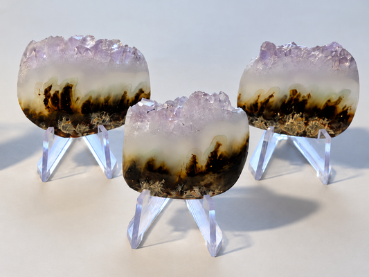 Three finished live-edge Chrysoplume cabochons